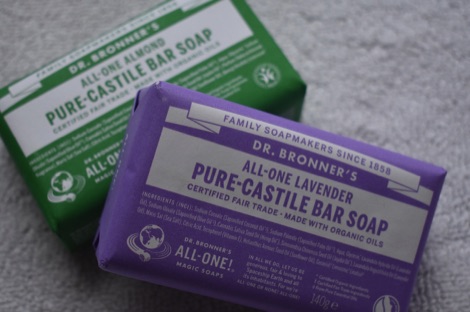 A purple bar of lavender Dr Bronners soap resting against a green bar of almond Dr Bronners soap